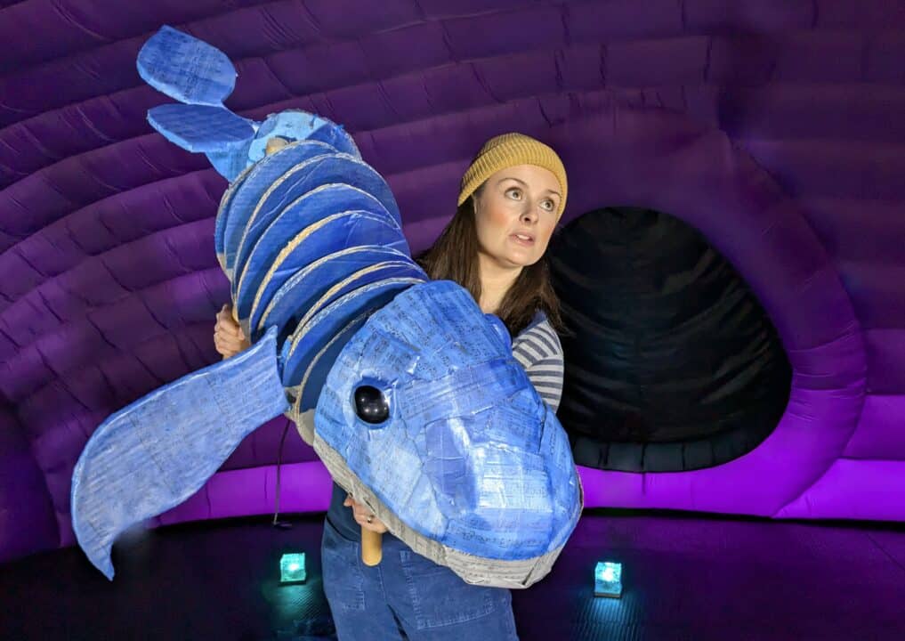 Image of a woman holding a whale puppet